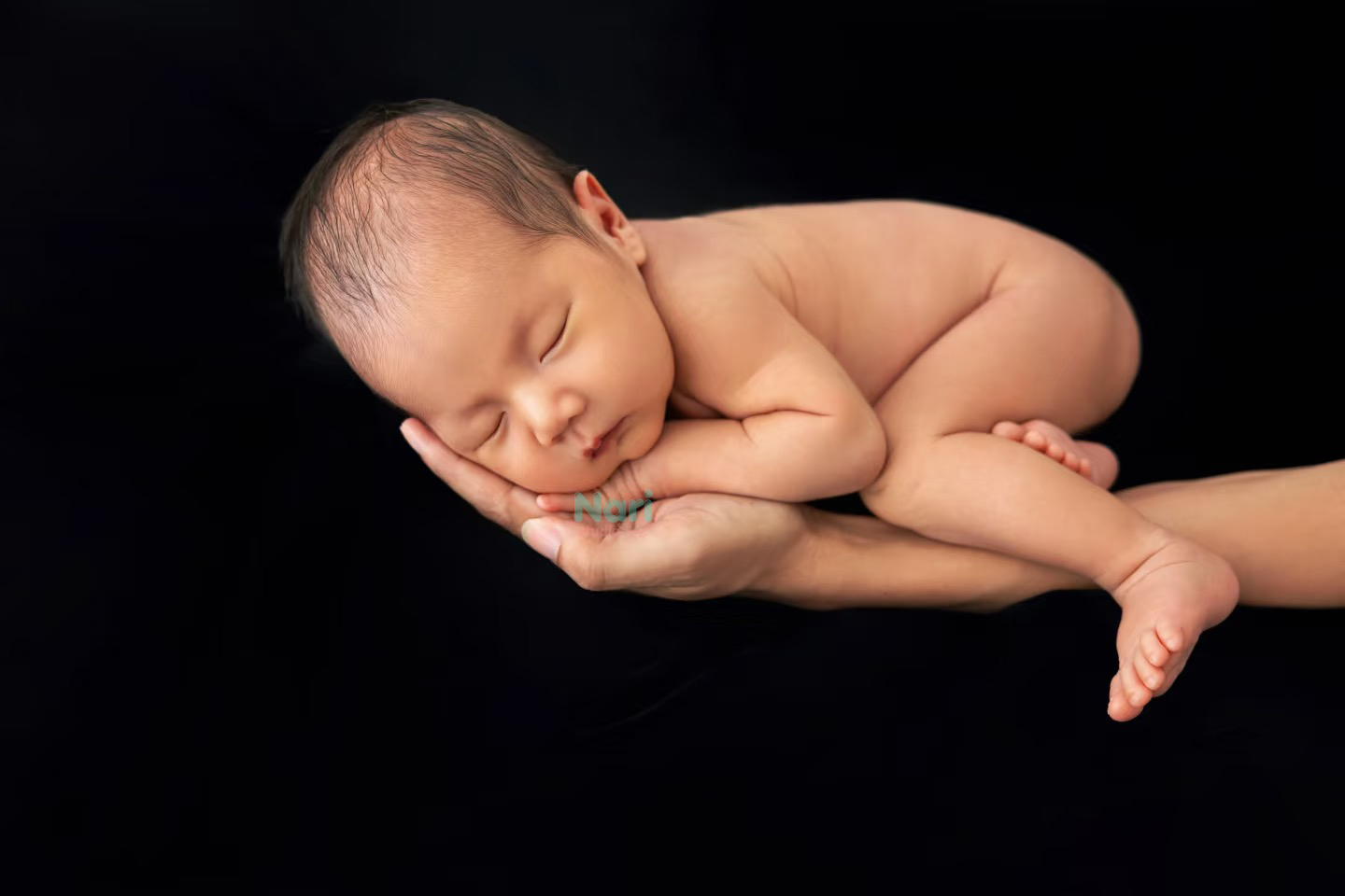 Bé ngủ trên bàn tay mẹ